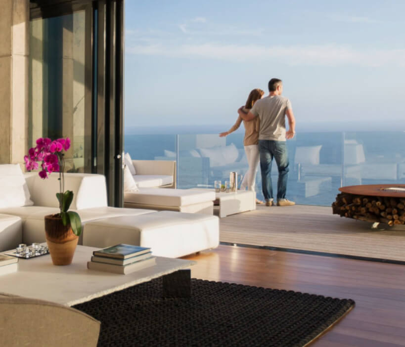 Couple admiring the view from the living room of their house.